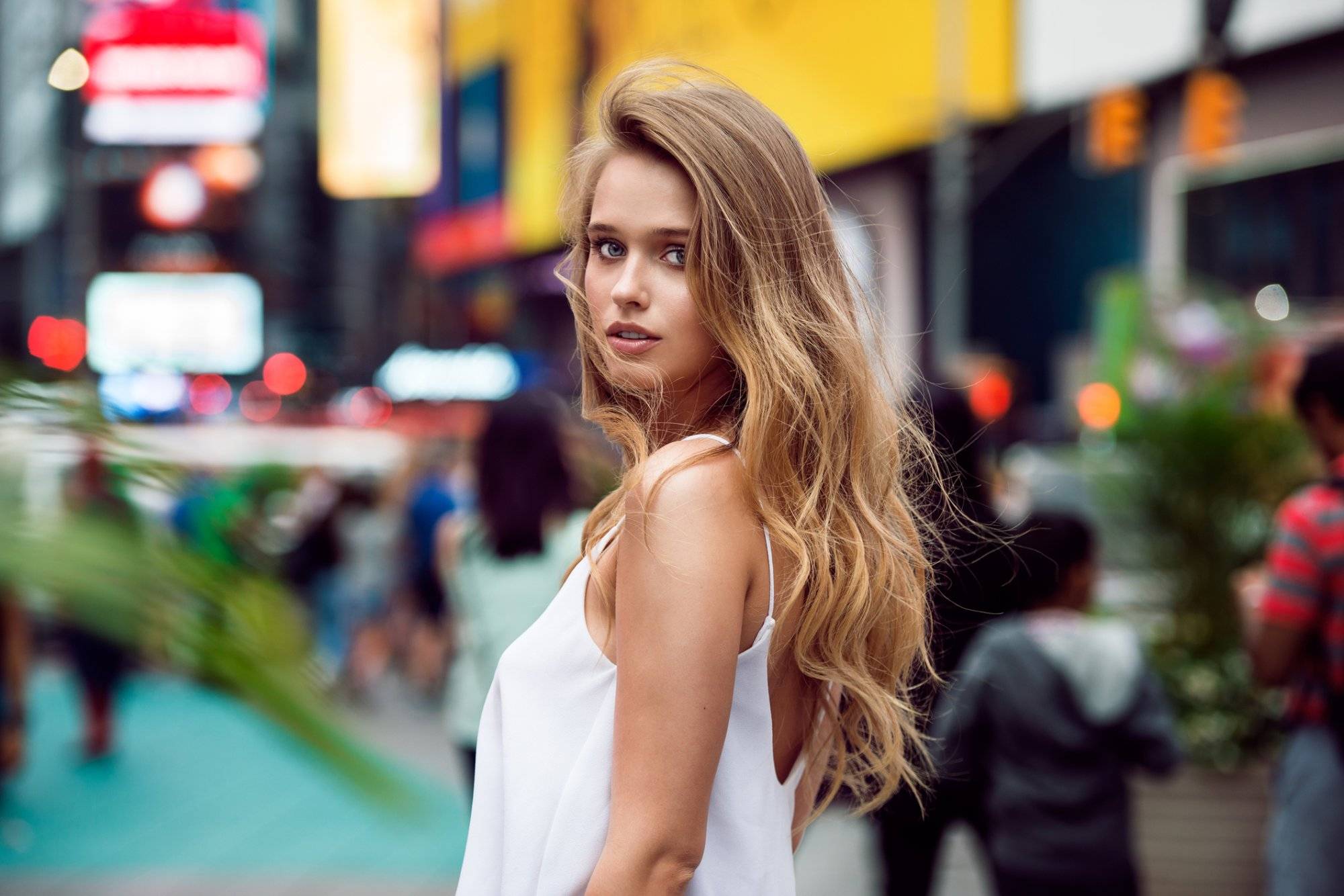 Beautiful blonde sexy tourist girl walking in busy city street Beautiful blonde sexy tourist girl walking in busy city street