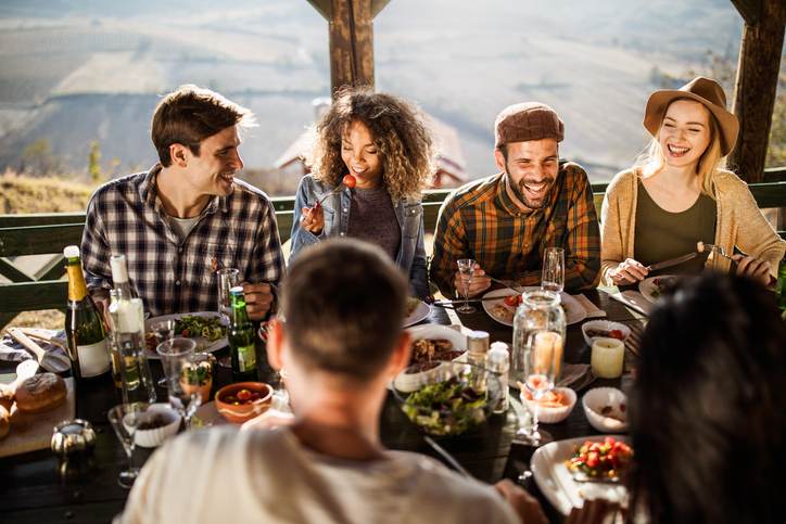 Happy friends talking during lunch on a terrace.