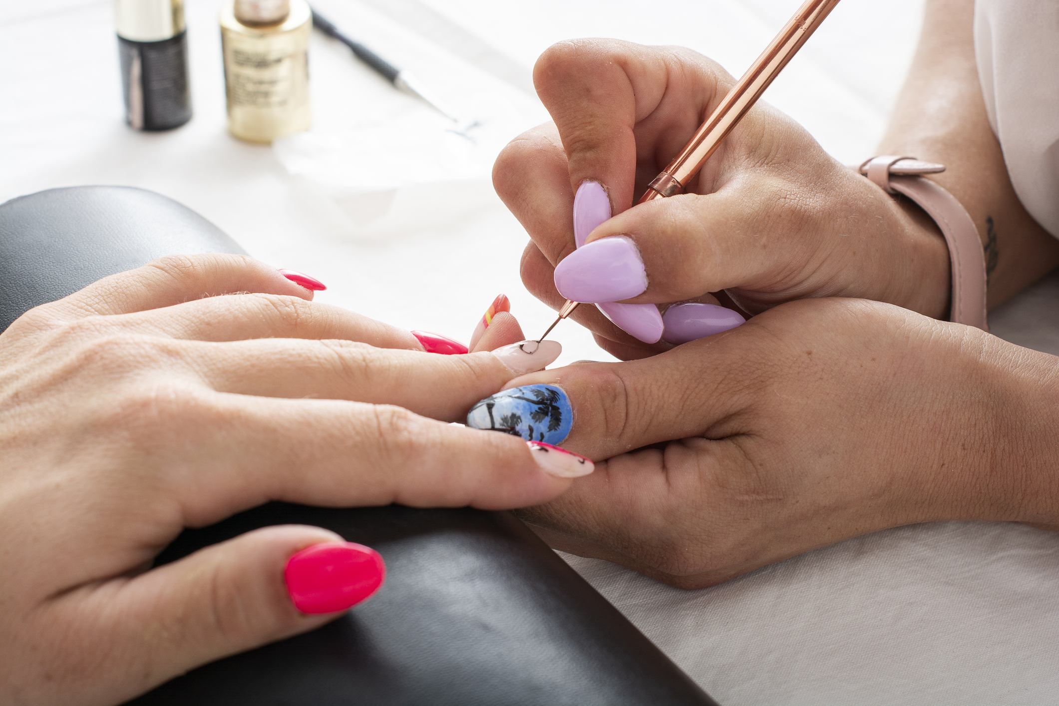 Woman getting her nails done in salon by manicure worker