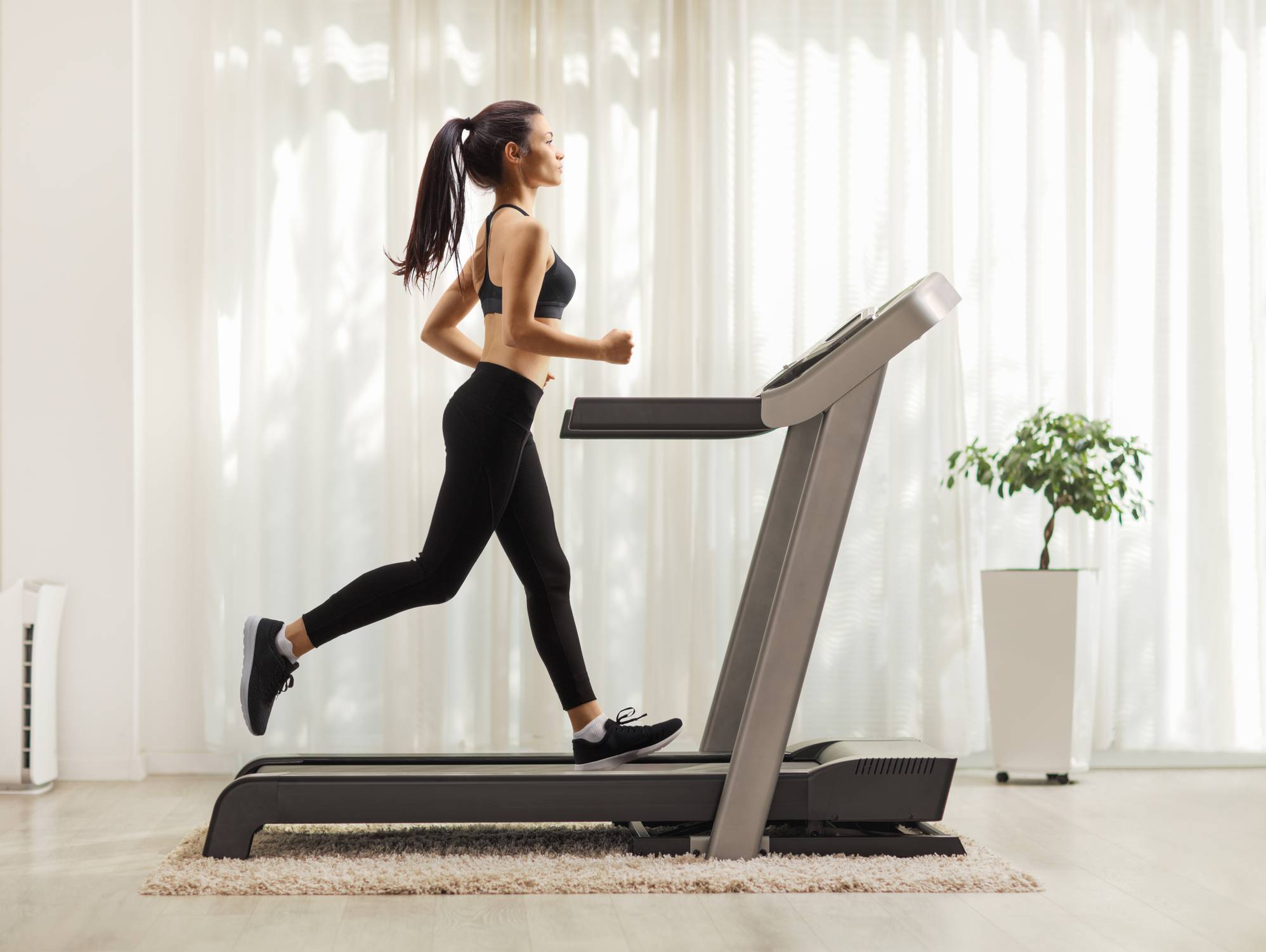 Young woman running on a treadmill indoors